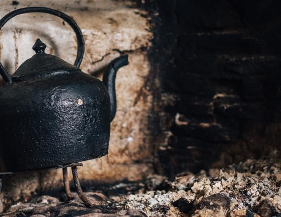 Image of a teapot on the hearth in a cottage at the Ulster American Folk Park