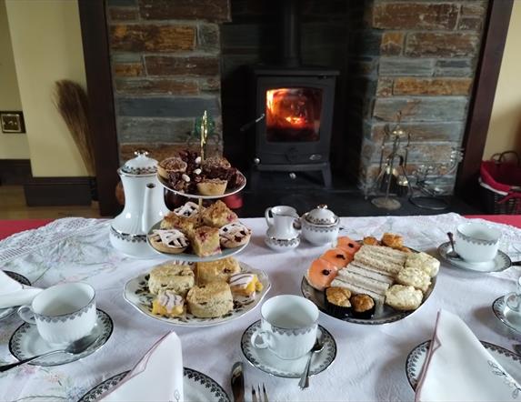 A table laid with plates of cakes and sandwiches