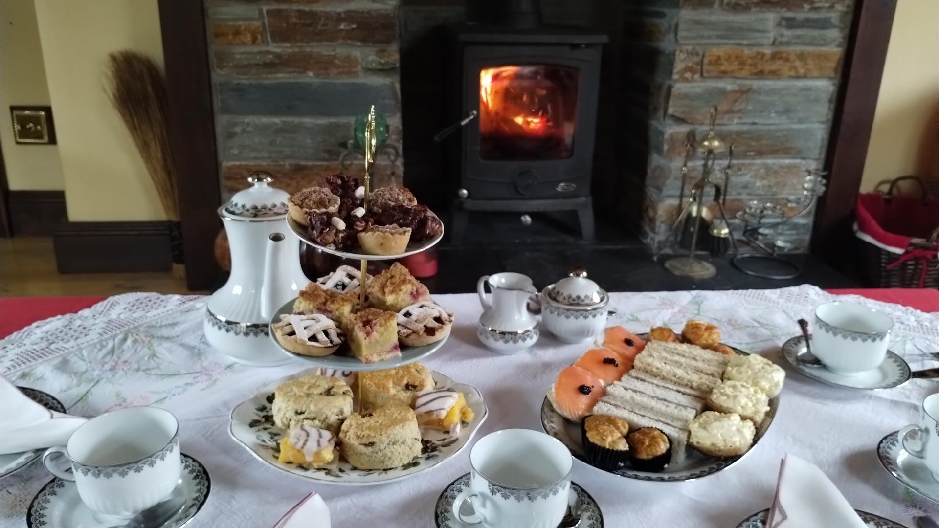 A table laid with plates of cakes and sandwiches