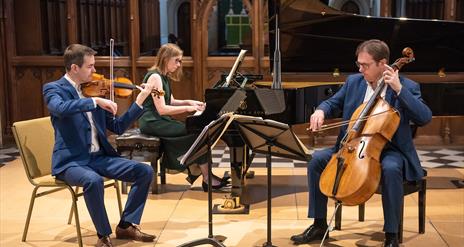 The Fidelio Trio pianist, violin and cello are shown mid performance