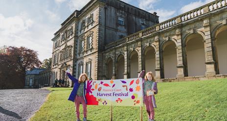 Two young visitors at the Harvest Festival sign outside Florence Court mansion