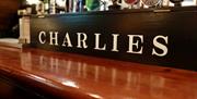 Draught beers on display behind a CHARLIES logo on the bar at Charlie's Bar Enniskillen.