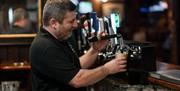 Bar man pouring a pint of Guinness at Charlie's Bar Enniskillen