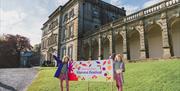 Two young visitors at the Harvest Festival sign outside Florence Court mansion