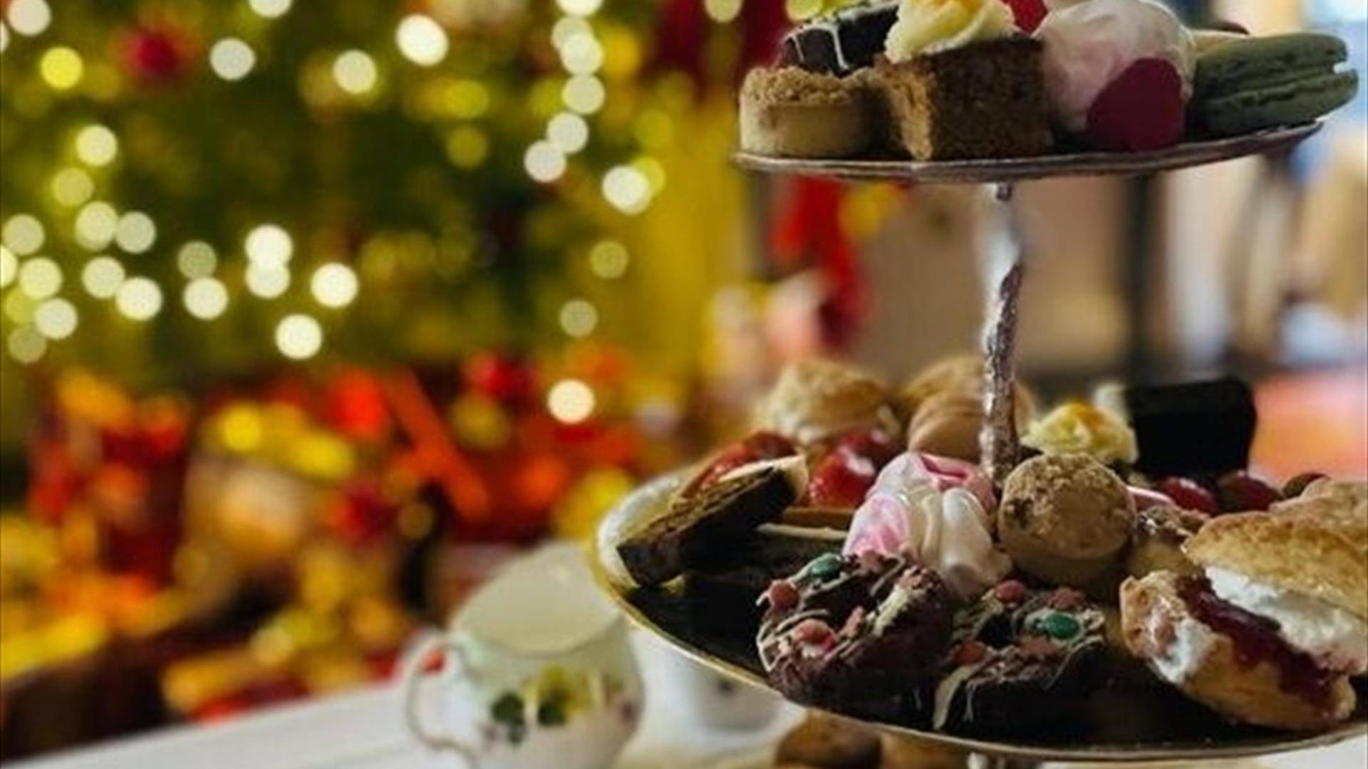 A close up of an afternoon tea with a Christmas tree in the background A close up of an afternoon tea with a Christmas tree in the background
